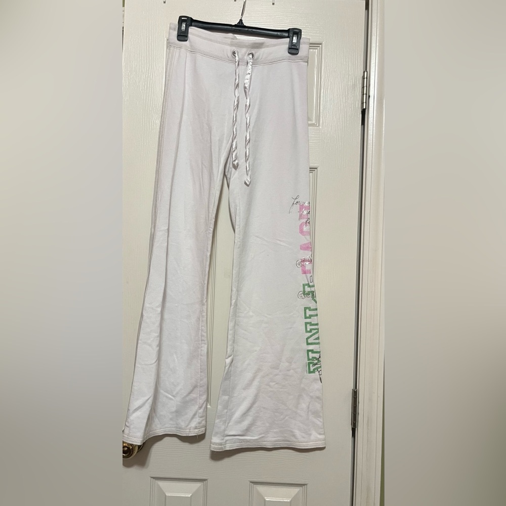 PINK vintage white yoga pants with back pockets and pink/green font on side.